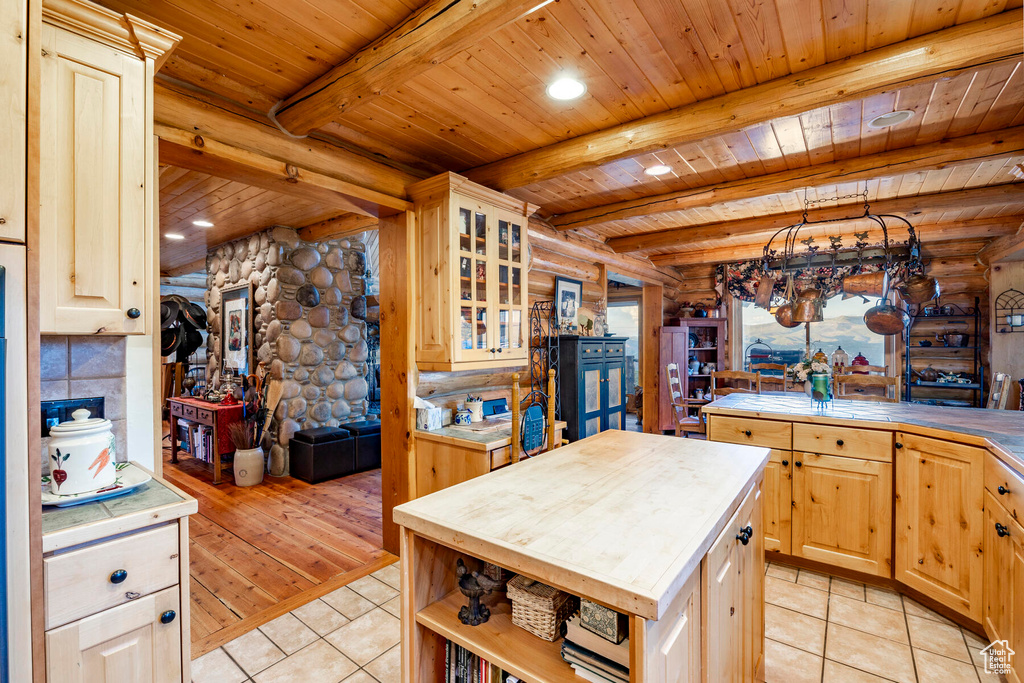 Kitchen featuring wooden counters, backsplash, beamed ceiling, wood ceiling, and log walls