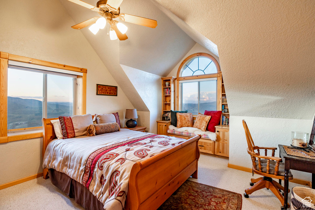 Bedroom with light carpet, vaulted ceiling, ceiling fan, and a mountain view