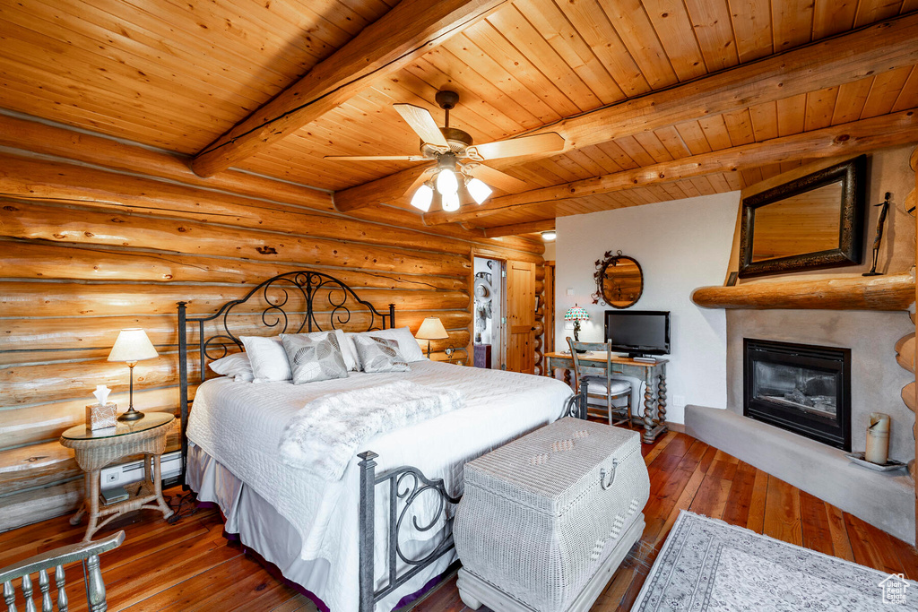 Bedroom with log walls, beamed ceiling, wooden ceiling, and hardwood / wood-style floors