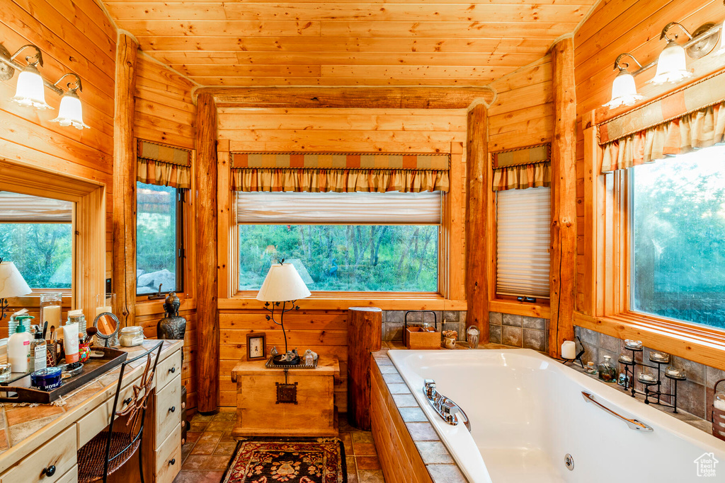 Bathroom with wooden walls, vanity, wooden ceiling, a bathing tub, and vaulted ceiling