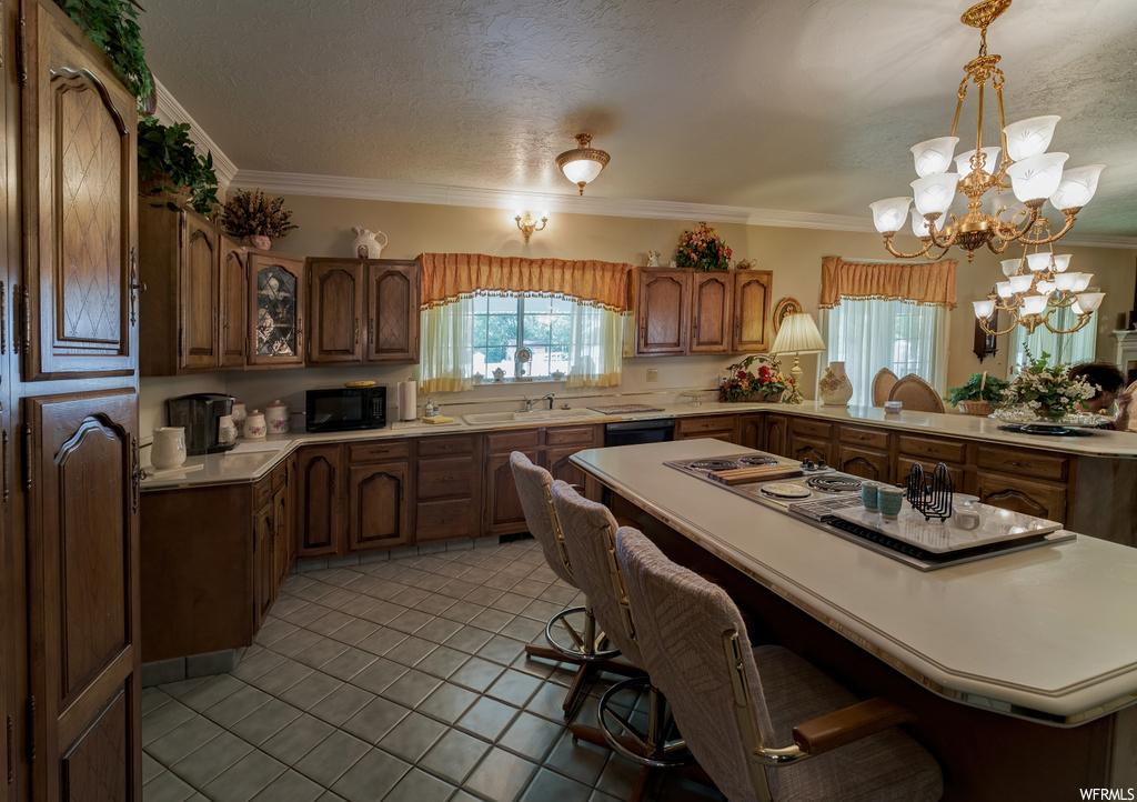 Kitchen with a kitchen breakfast bar, natural light, microwave, dishwasher, light countertops, and light tile flooring