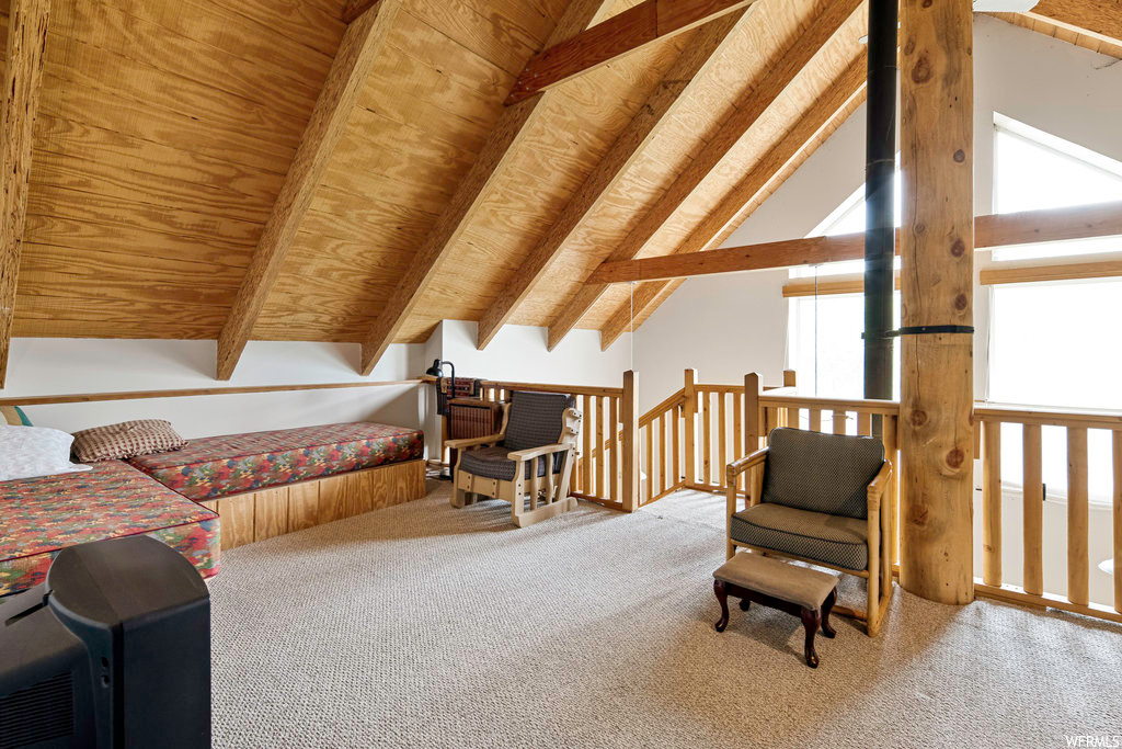 Living area with carpet and lofted ceiling with beams