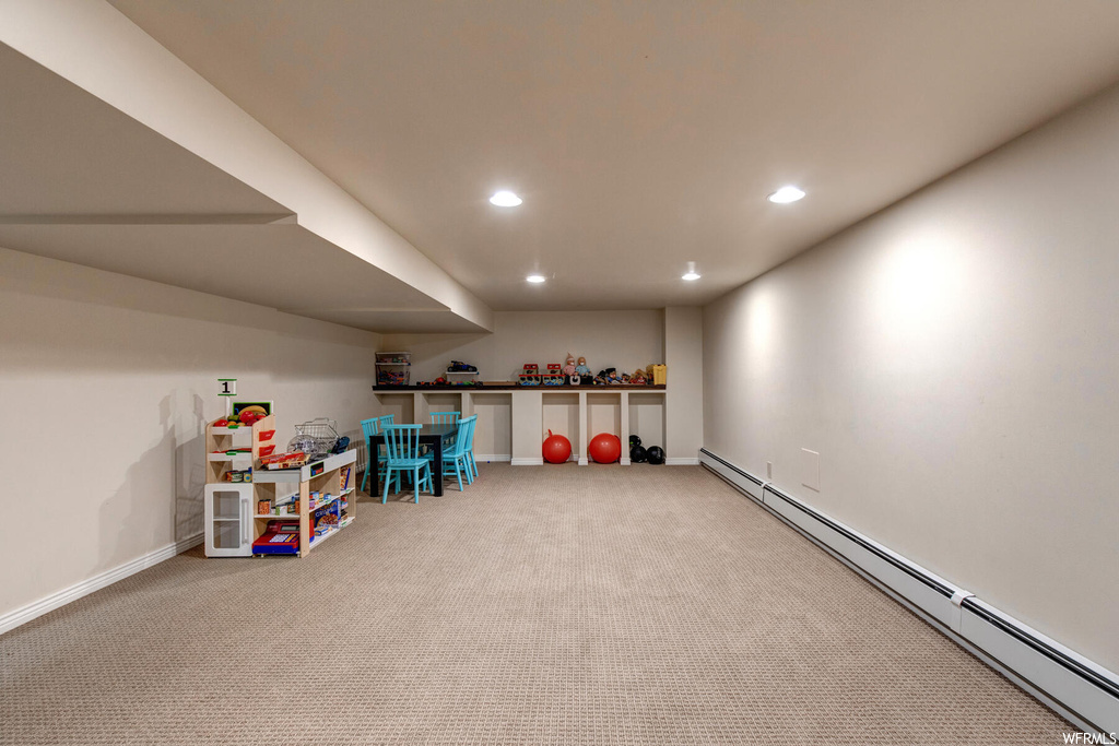 Rec room featuring a baseboard radiator and light colored carpet