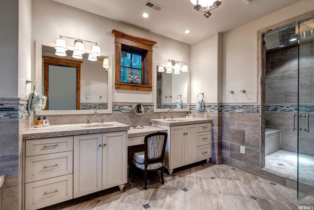 Bathroom with walk in shower, tile walls, dual bowl vanity, and tile floors