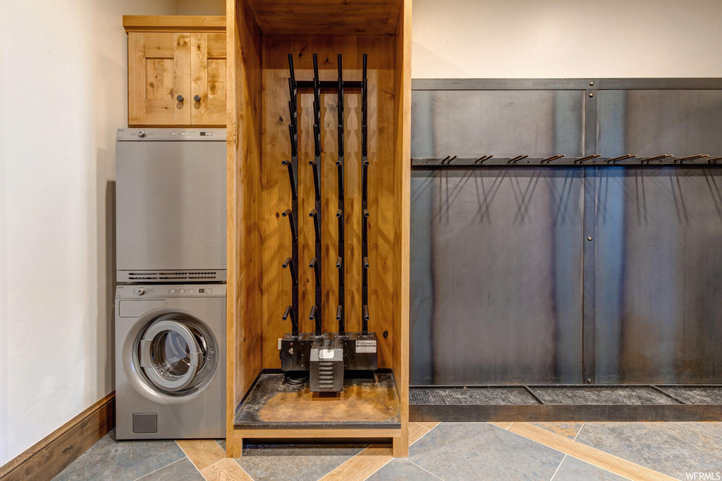 Laundry area featuring stacked washer and dryer and tile floors