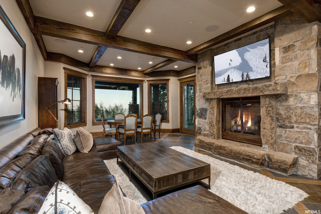 Living room featuring beamed ceiling and a fireplace