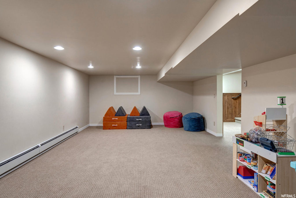 Rec room featuring a baseboard radiator and light carpet
