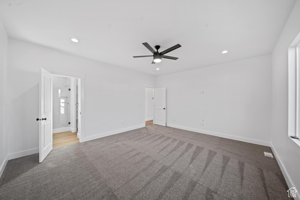 Carpeted empty room featuring ceiling fan