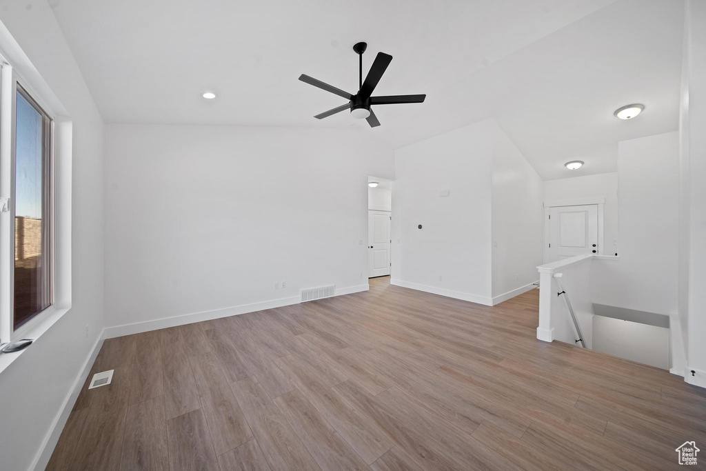 Unfurnished room with light hardwood / wood-style flooring, ceiling fan, and vaulted ceiling