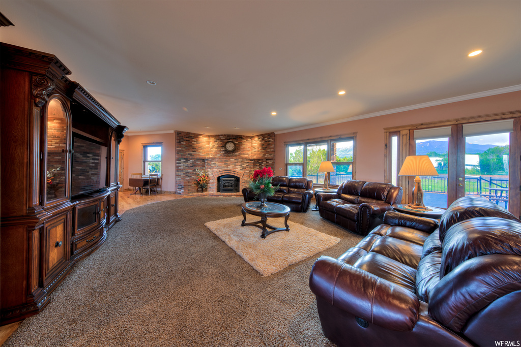 Carpeted living room with a fireplace and a healthy amount of sunlight