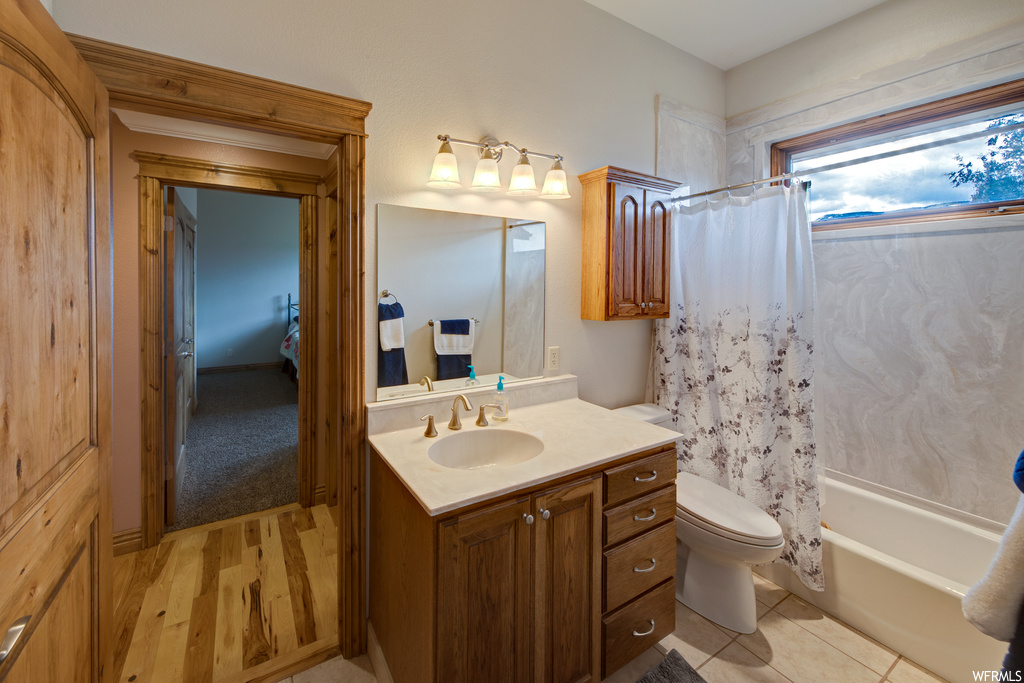 Full bathroom featuring vanity, toilet, shower / tub combination, dual mirrors, and shower curtain