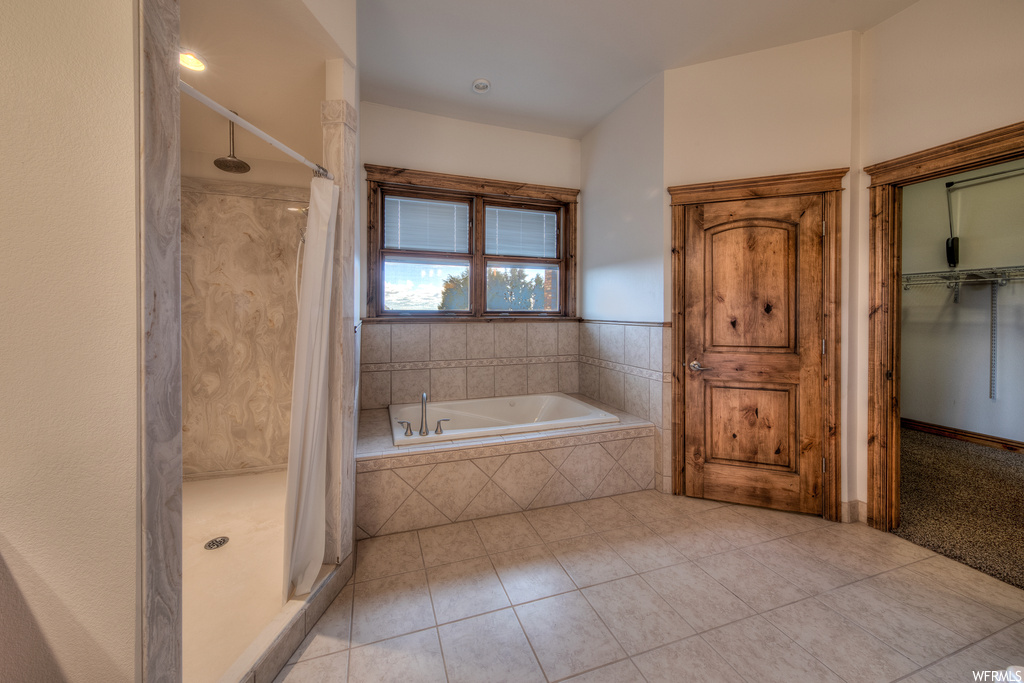 Bathroom with natural light, shower curtain, and shower with separate bathtub