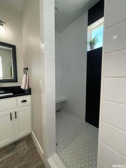Bathroom with vanity, mirror, and a shower