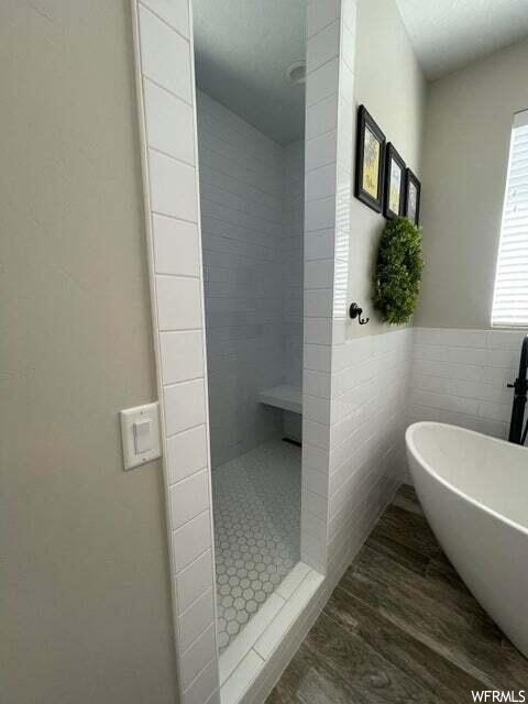 Bathroom featuring natural light and separate shower and tub