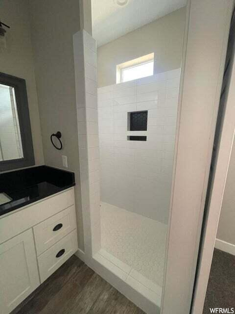 Bathroom with mirror, a shower, and vanity