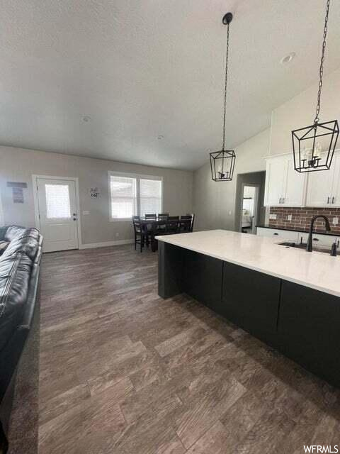 Kitchen featuring hardwood floors, natural light, pendant lighting, and light countertops