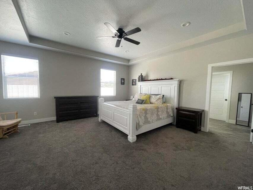 Bedroom with carpet, a ceiling fan, and natural light