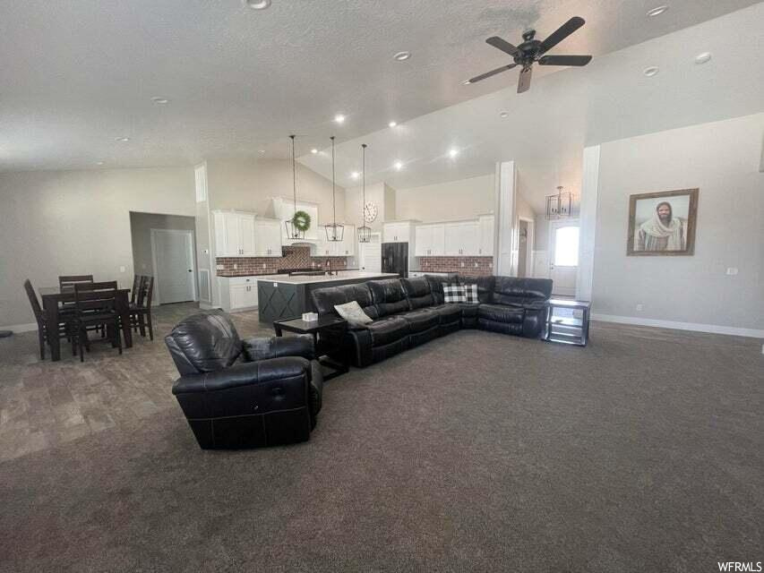 Living room featuring carpet and a ceiling fan