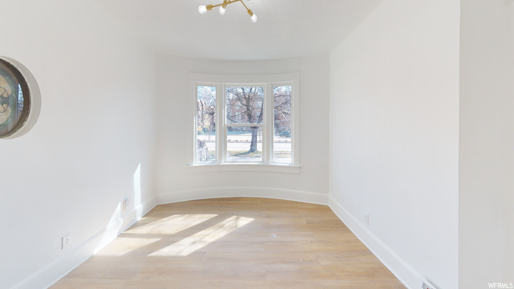 Spare room with hardwood floors and natural light
