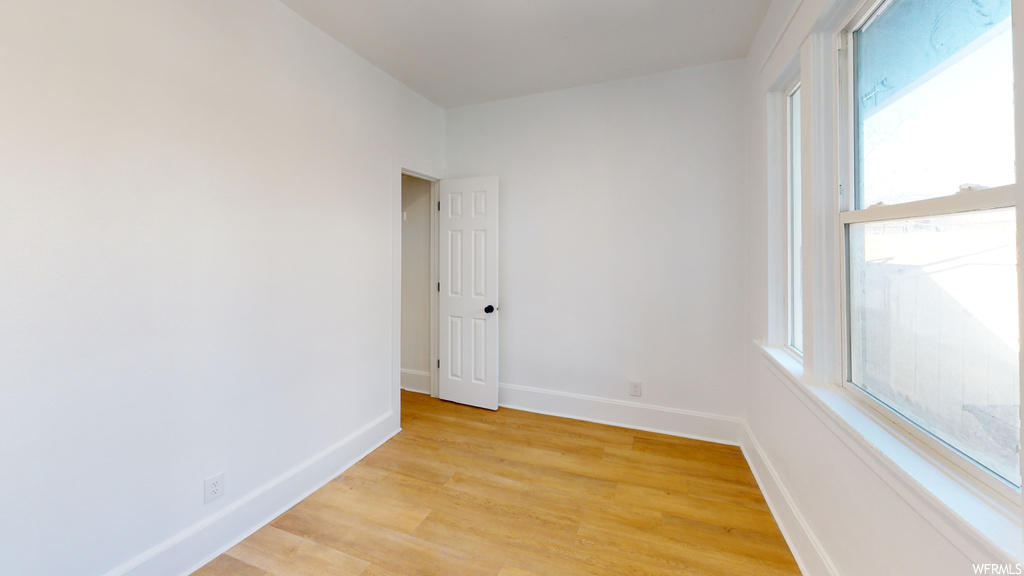 Spare room featuring natural light and hardwood flooring