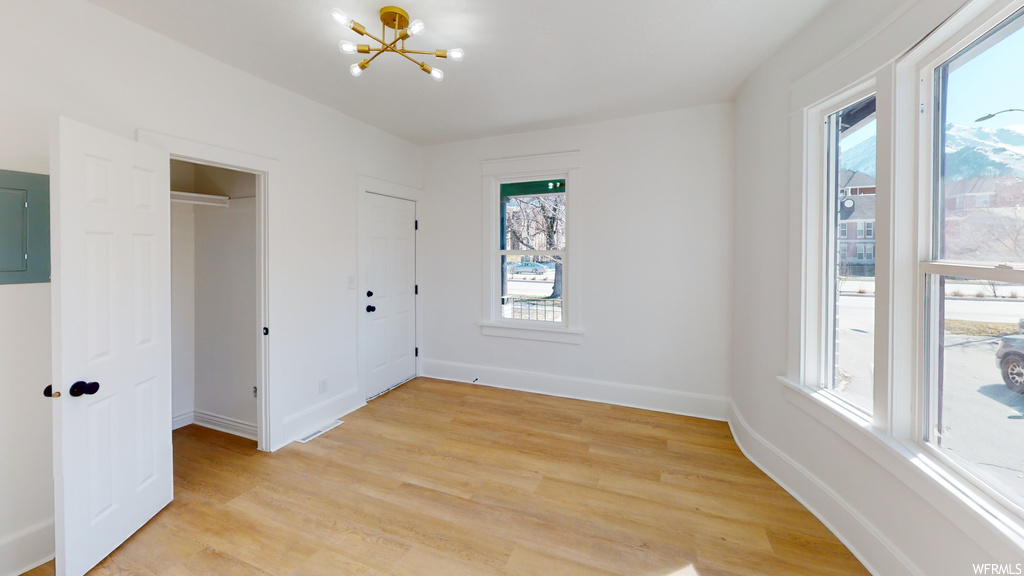 Hardwood floored bedroom featuring multiple windows