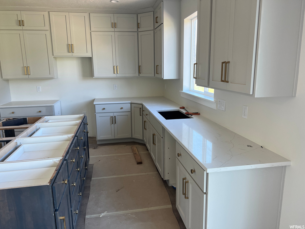 Kitchen featuring white cabinets and light countertops