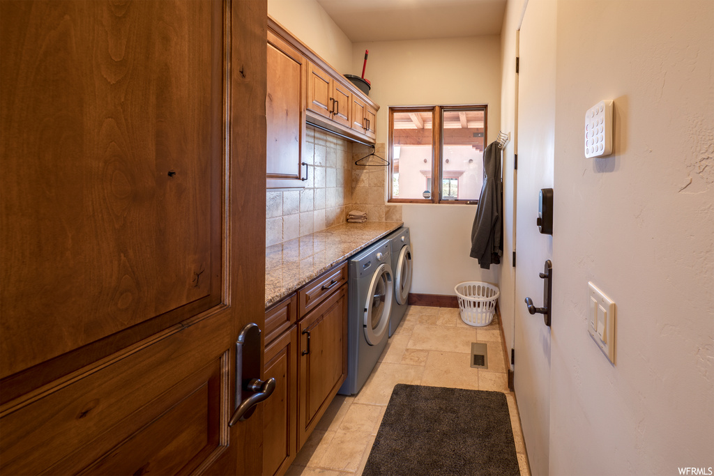 Laundry area with tile floors and washer / dryer