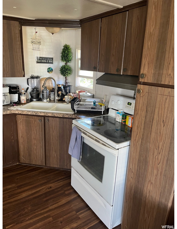 Kitchen with premium range hood, white range with electric cooktop, and dark hardwood floors