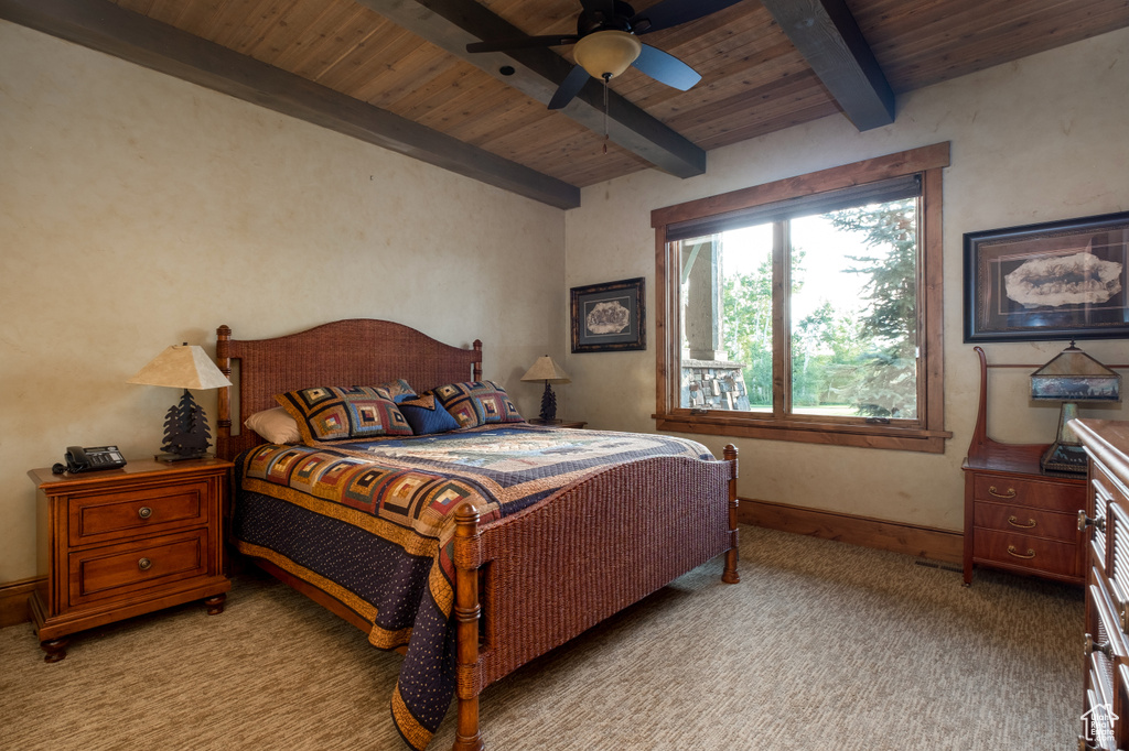 Bedroom featuring beamed ceiling, baseboards, ceiling fan, light colored carpet, and wood ceiling