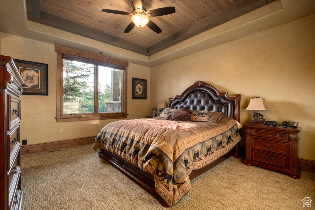 Bedroom featuring light carpet, baseboards, ceiling fan, a raised ceiling, and wood ceiling