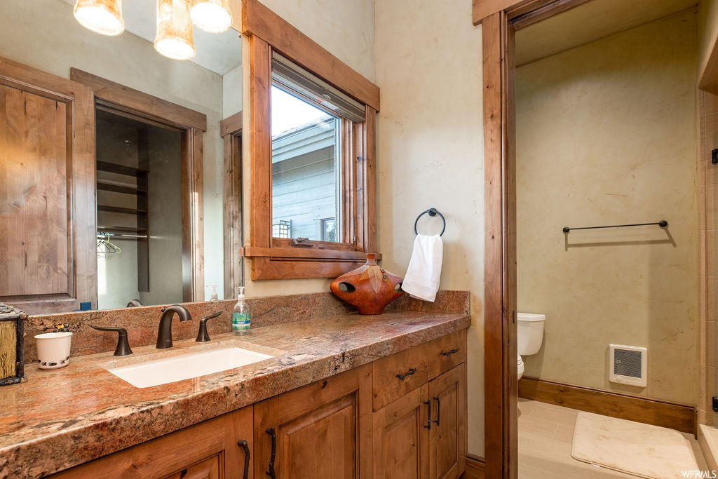 Half bath featuring mirror, toilet, and oversized vanity