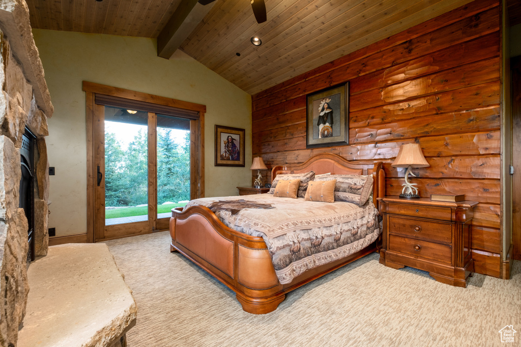 Carpeted bedroom featuring access to outside, wooden ceiling, vaulted ceiling with beams, and a fireplace