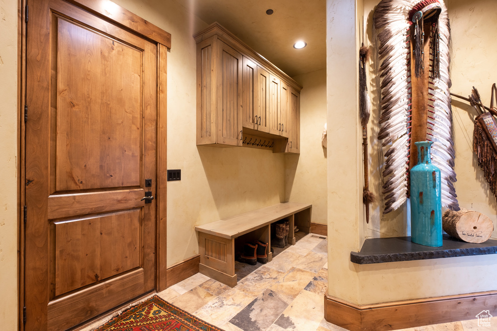 Mudroom featuring recessed lighting, baseboards, and stone finish flooring
