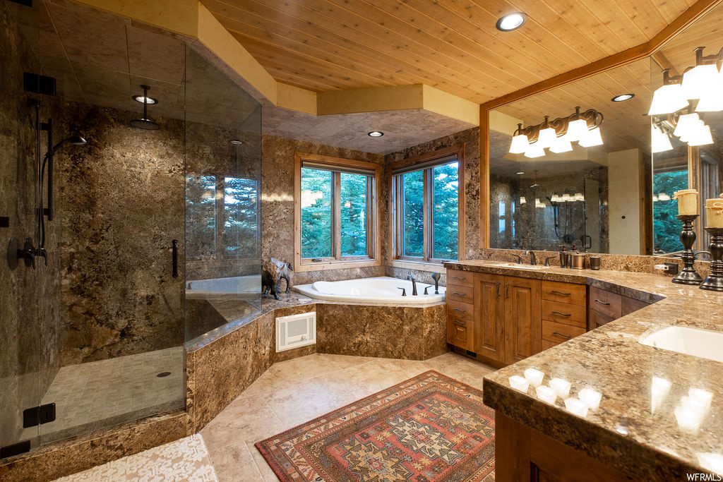 Bathroom featuring natural light, mirror, separate shower and tub, and his and hers vanity