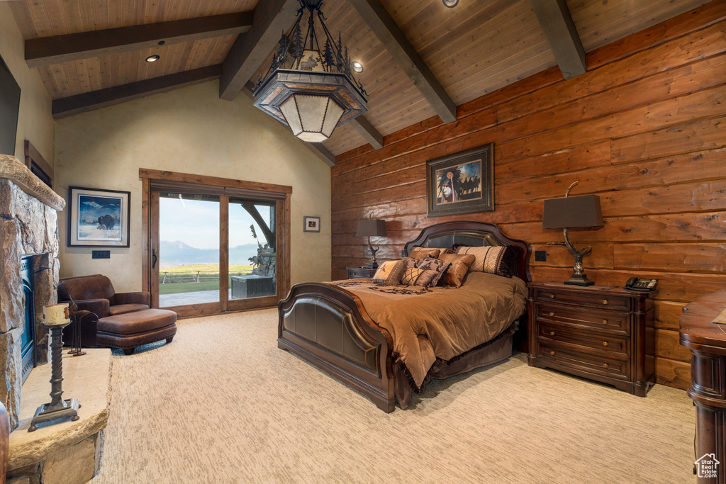 Bedroom featuring wood walls, beamed ceiling, light colored carpet, and access to exterior