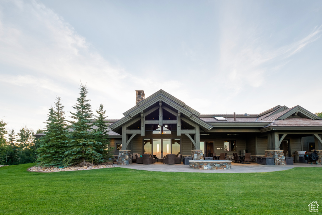 Back of house with a lawn, outdoor lounge area, a chimney, and a patio area
