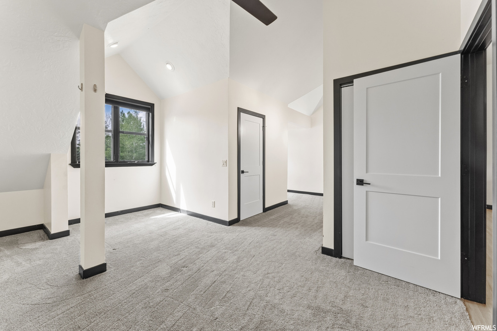 Carpeted empty room with lofted ceiling