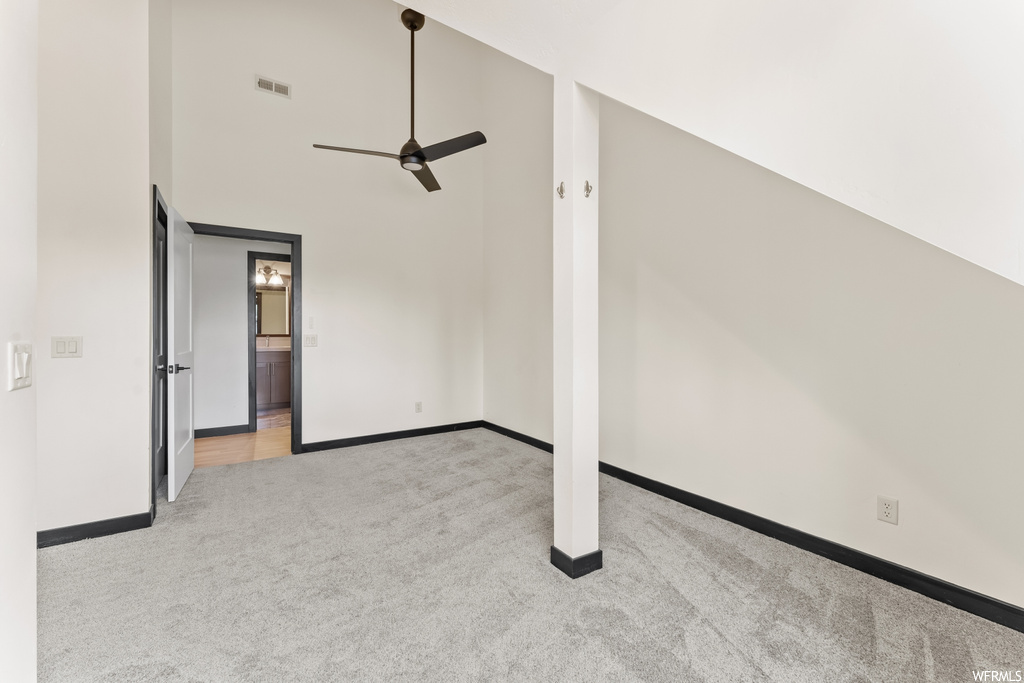 Additional living space with a ceiling fan and carpet