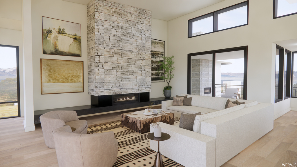 Living room featuring a fireplace, hardwood flooring, and natural light