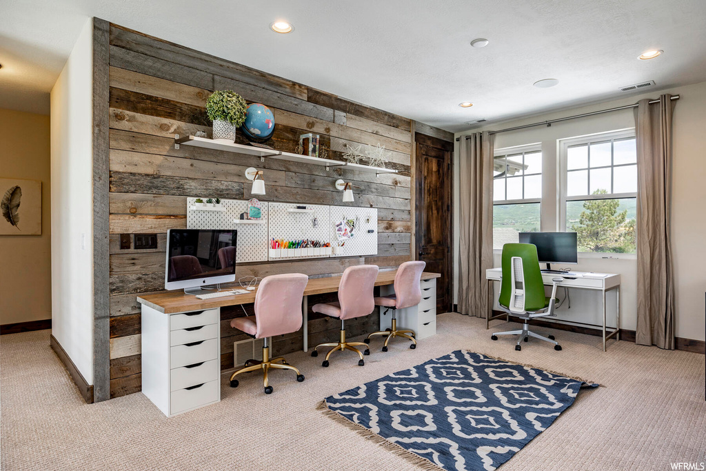 Carpeted office with natural light and TV