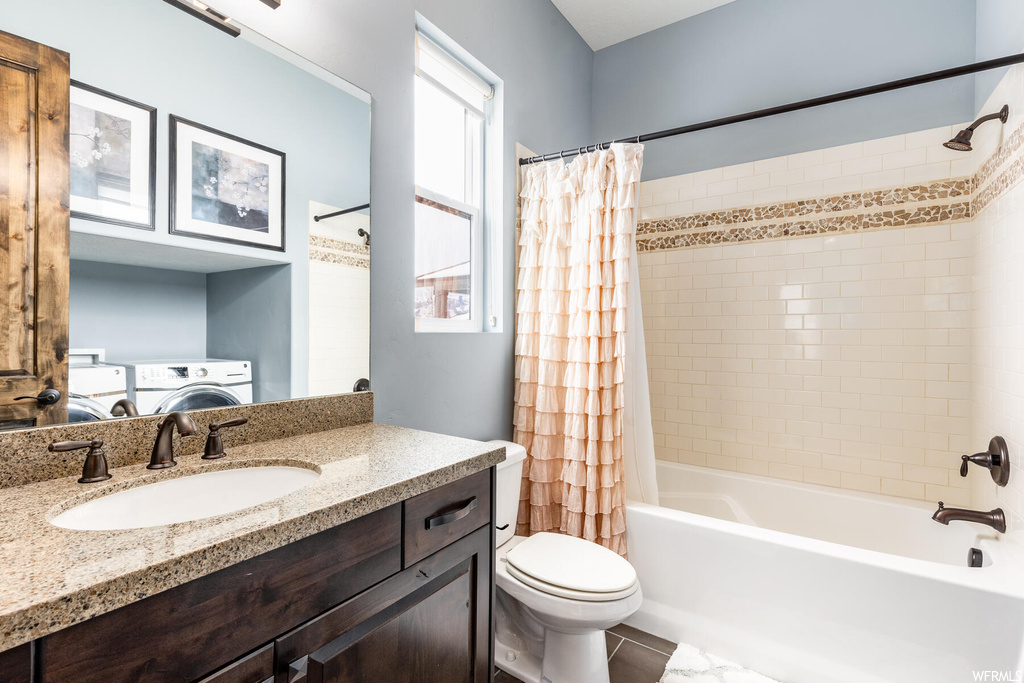 Full bathroom featuring washer / dryer, vanity, shower curtain, bathing tub / shower combination, mirror, and toilet