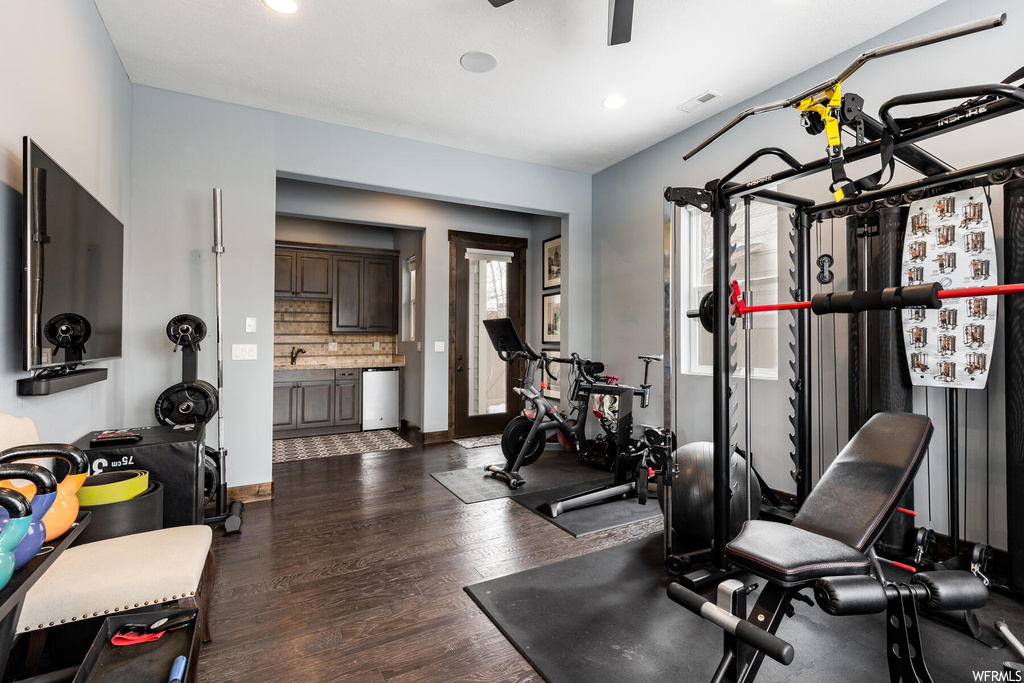 Workout area with hardwood floors and TV
