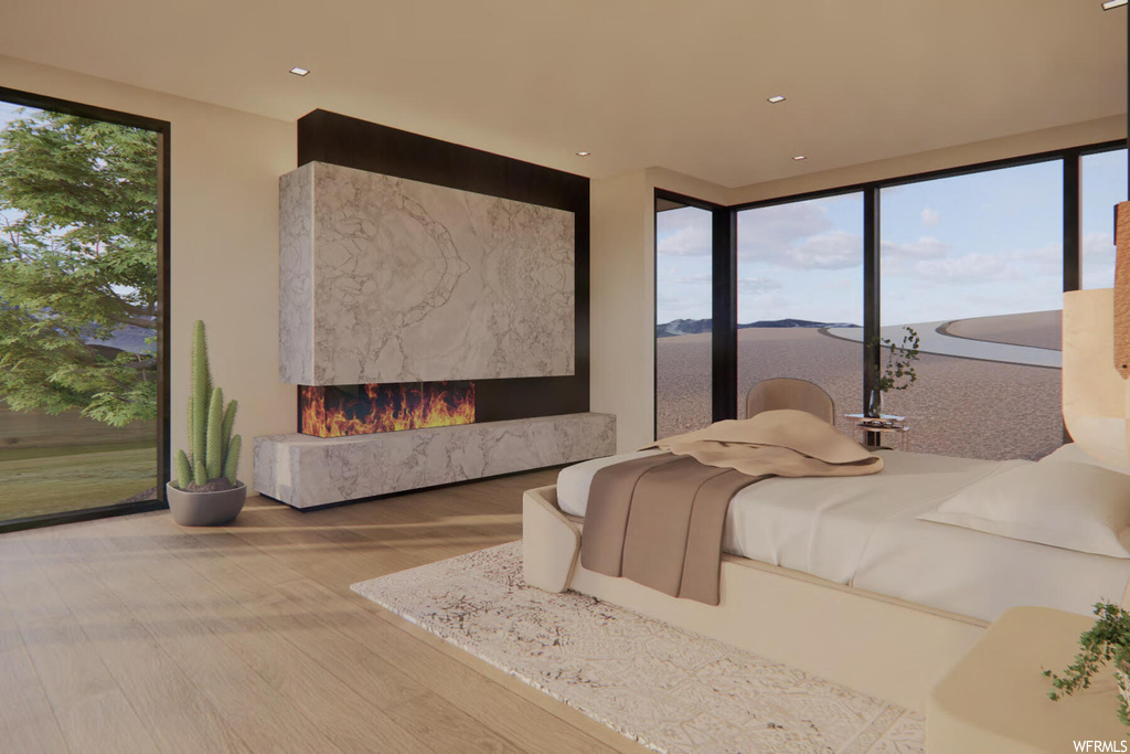 Bedroom with light hardwood / wood-style flooring, a fireplace, and multiple windows