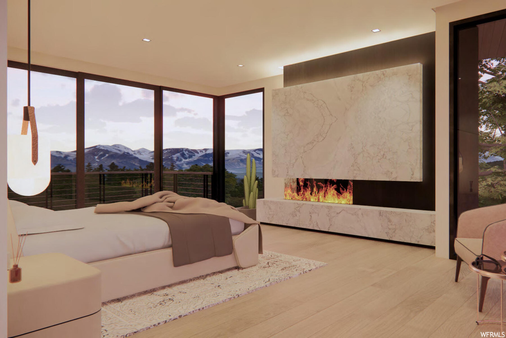 Bedroom with light hardwood / wood-style flooring, a premium fireplace, a wall of windows, and a mountain view