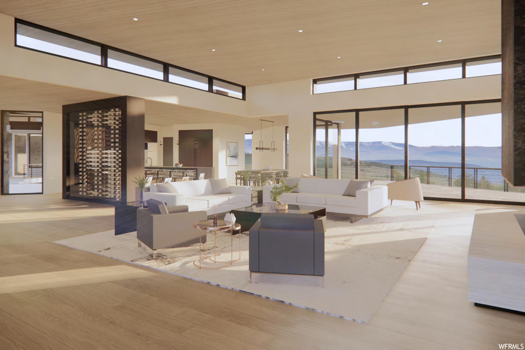 Interior space with a towering ceiling, light hardwood / wood-style floors, and a mountain view