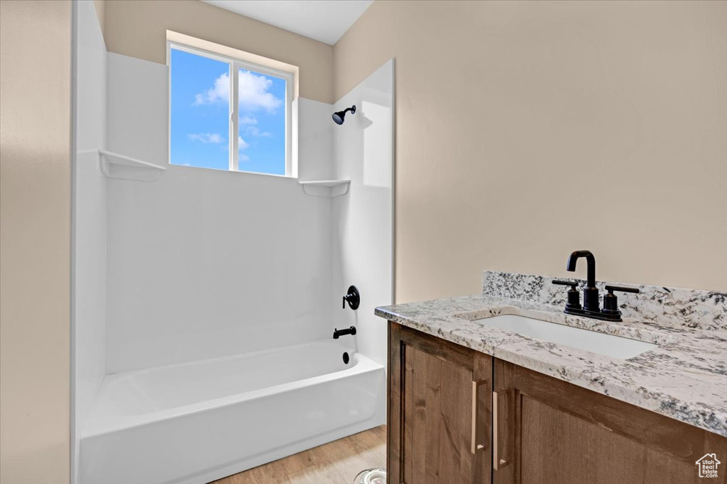 Bathroom featuring vanity, tub / shower combination, and hardwood / wood-style flooring
