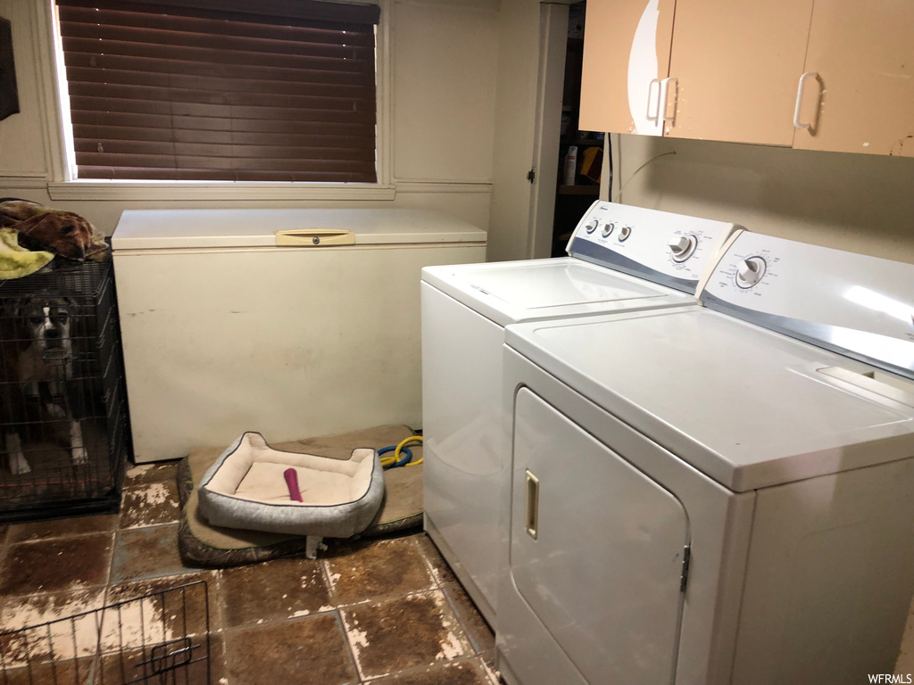 Laundry area with tile floors and independent washer and dryer