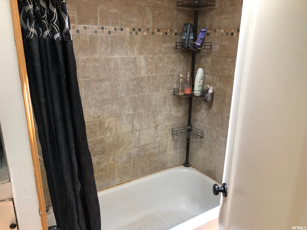Bathroom featuring shower curtain and bathing tub / shower combination
