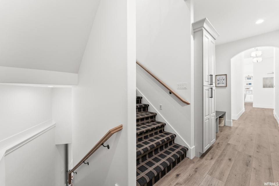 Staircase featuring hardwood flooring
