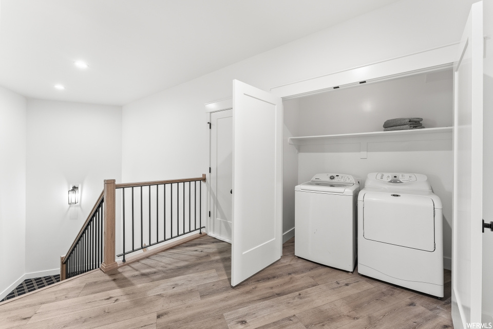 Laundry room with hardwood flooring and independent washer and dryer